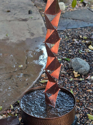 Origami™ Rain Chain in copper plated stainless steel with water running down to a cylinder basin