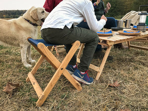 The Deluxe lightweight Folding Stool used as seat at camp