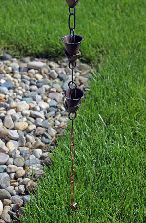 Copper rain chain anchor stake securing cup style rain chain to ground