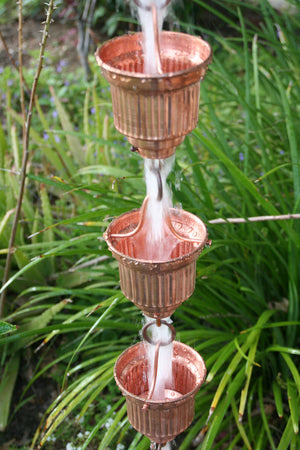 Copper Naoki Cups Rain Chain with water flowing through multiple cups