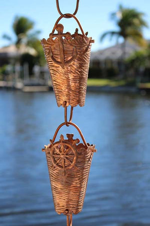 Nautical Cups Copper Rain Chain with ships wheel accent in front of water
