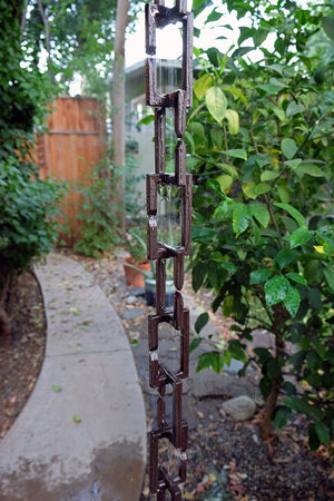 Bronze Rectangle Links Rain Chain with flowing rain water in garden