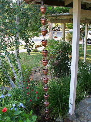 Acorn Cups Rain Chain on house with water flowing through multiple cups