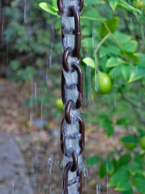 Multiple links of Bronze Aluminum Anchor Rain Chain with water flowing down links