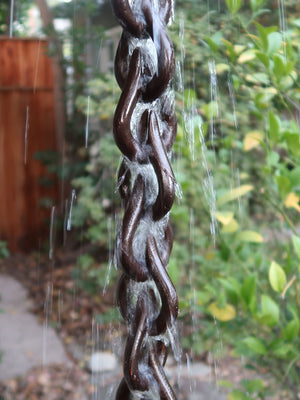 Bronze droplet rain chain with water flowing through