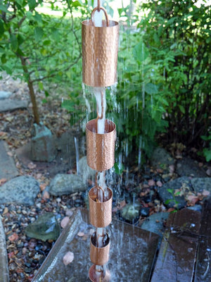 Copper Kenchiku Rain Chain with water running through multiple cups