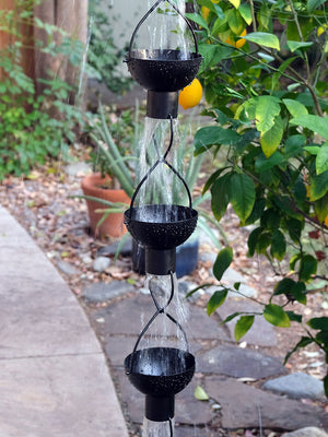 Black modern flower cup rain chain with water flowing through cups