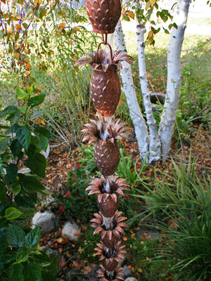 Pineapple Theme Copper Rain Chain on house with water running through multiple cups