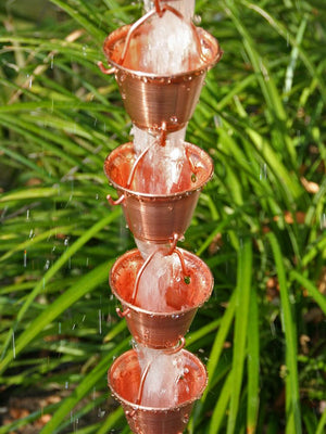 Copper Shizuka Cups Rain Chain with water flowing through multiple cups