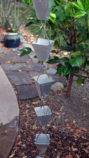 longer section of aluminum Tapered Square Cups Rain Chain with water droplets on the cups