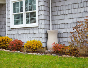 Impressions 50 Gallon Corsican Rain Saver sitting next to a beautiful house