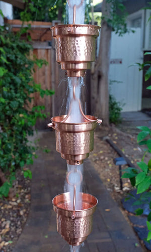 Copper Naoki Cups Rain Chain with water flowing through multiple cups