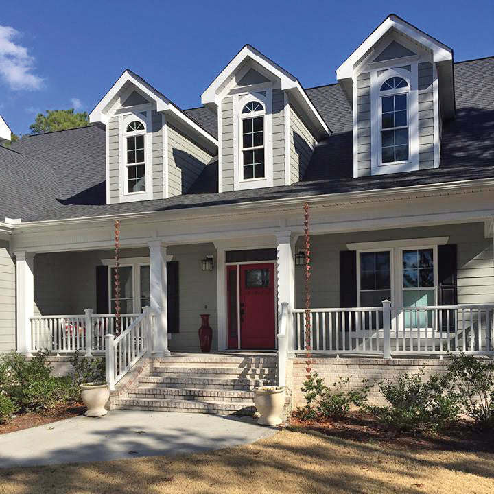 This photo shows two of our Copper Medium Square Cups Rain Chain handing on either side of the front entry steps. 