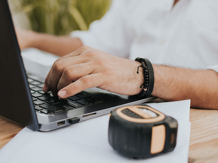 Person ordering a rain chain with a tape measure next to their computer