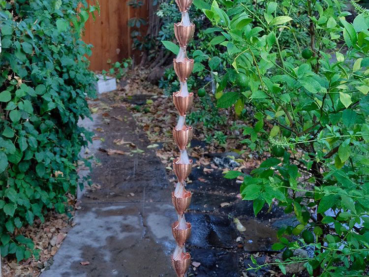 Copper Cup Style Rain Chain with water flowing through it
