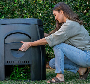 woman opening the side of the 63 gallon compost bin