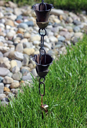 Copper rain chain anchor stake securing rain chain to yard