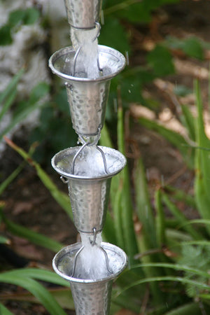 Flared Cups Rain Chain in aluminum with water flowing through multiple cups