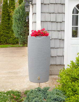 Impressions Stone 50 Gallon Rain Saver in Light Granite next to grey house