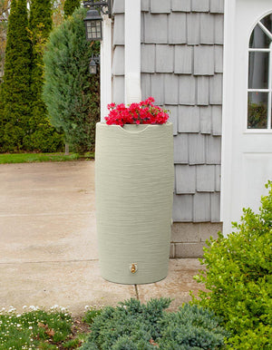 Impressions Stone 50 Gallon Rain Saver in Sandstone next to grey house