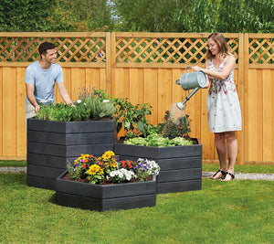 watering Modular Raised Garden Beds in a yard