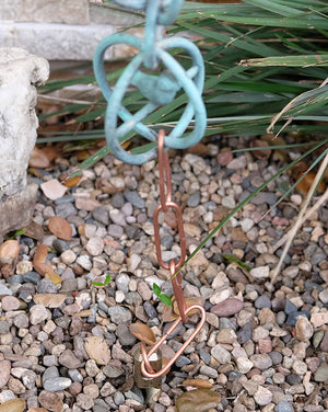 Copper rain chain anchor stake securing rain chain to ground