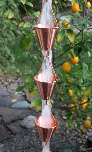Full length image of Copper colored Steel Cups Rain Chain with water running through cups