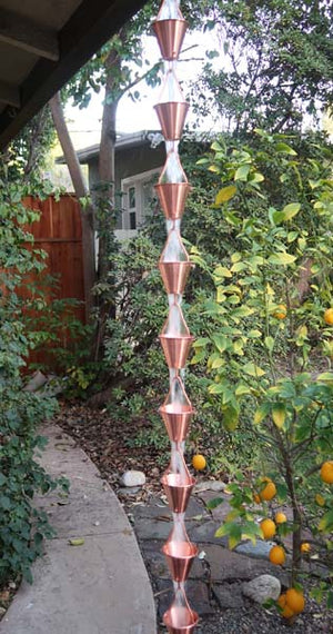 Full length image of Copper colored Steel Cups Rain Chain on home with water running through cups