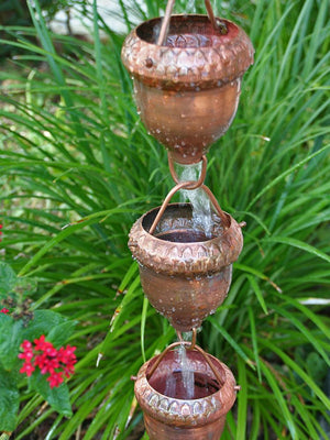 Acorn Cups Copper Rain Chain with water flowing through multiple cups