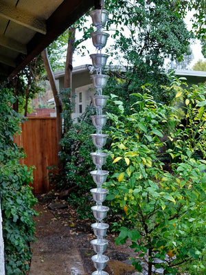 Aluminum Bell Cups Rain Chain on house with water flowing through multiple cups