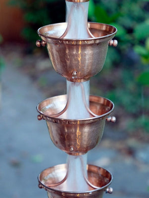 Copper Bell Cups Rain Chain with water flowing through multiple cups