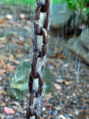 Cast Oval Links Rain Chain in bronze during heavy rain