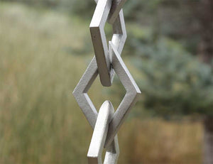 Close up showing hand cast detail of the Diamond Links Rain Chain in clear powder-coated Aluminum