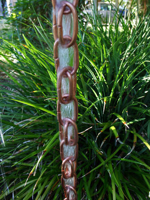 Closeup of copper Extra Link Rain Chain with water flowing through it