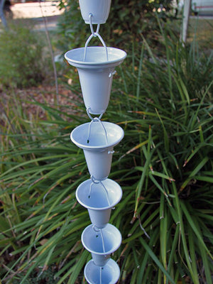 Flared Cups Rain Chain in White on home with water flowing through multiple cups