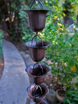 Bronze Flower Cups Rain Chain with water flowing through multiple cups