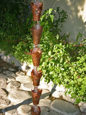 Grape Leaf Theme Copper Rain Chain with water flowing through multiple cups in backyard