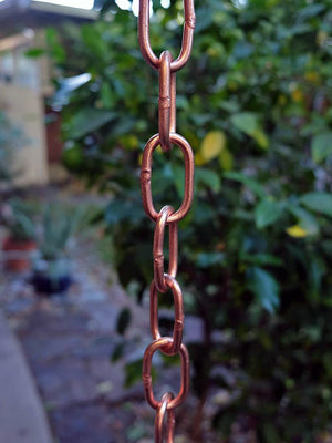 Large Copper Link Rain Chain hanging from a home