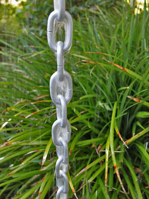 Full length Large Link Rain Chain in silver with water running through it