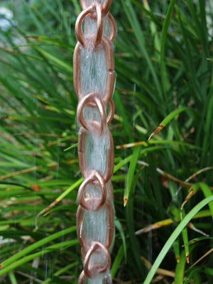 Full length image of Link & Loop Copper Rain Chain with water running through it