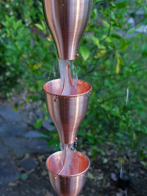 Copper Smooth Cups Rain Chain with water flowing through multiple cups