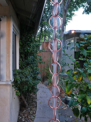 Full length view of Zen Loops Copper Rain Chain with water flowing through it
